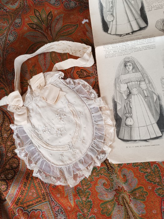 French Brocante - For Sale - 1900's First Communion Silk Aumoniere Purse no1Description: <p>An essential part of the First Communion costume these small money purses hung from the sash at the waist of the dress</p>

<p>This one has an embroidered chiffon front and chiffon and lace trim, all in good condition except for some damage to the carrying ribbon from being pinned to the sash</p>

<p>The variety of designs makes them a great collectable and wonderful to display in groups for the maison romantique interior</p>
