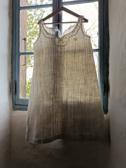 French Brocante - For Sale - Vintage Trousseau Linen NightgownDescription: <p>A line shape with high relief embroidery, pearl button fastening on the top of each strap , this is heavy antique linen, off white with a wonderful texture</p>

<p>A few small holes and a tear at the front that need repairing, also a medium size tear at the back but worth it to save a beautiful nightgown </p>

<p>Chest 40", length 41"</p>
