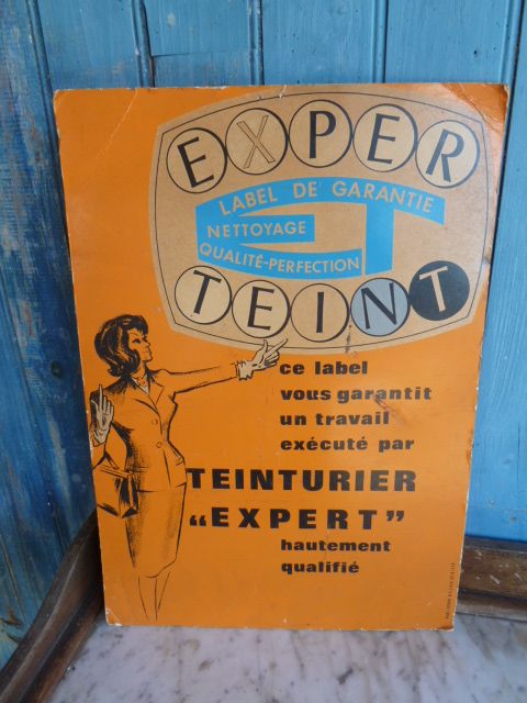 French Brocante - For Sale - Shop Advertising Card for Dye Description: <p>1950's card advertising poster for Teinture "Expert"</p>

<p>It would have sat on a counter with the easel attachment or hung on the wall, the hanging tab is missing but the easel still holds it up</p>

<p>In good used condition</p>

<p> </p>
